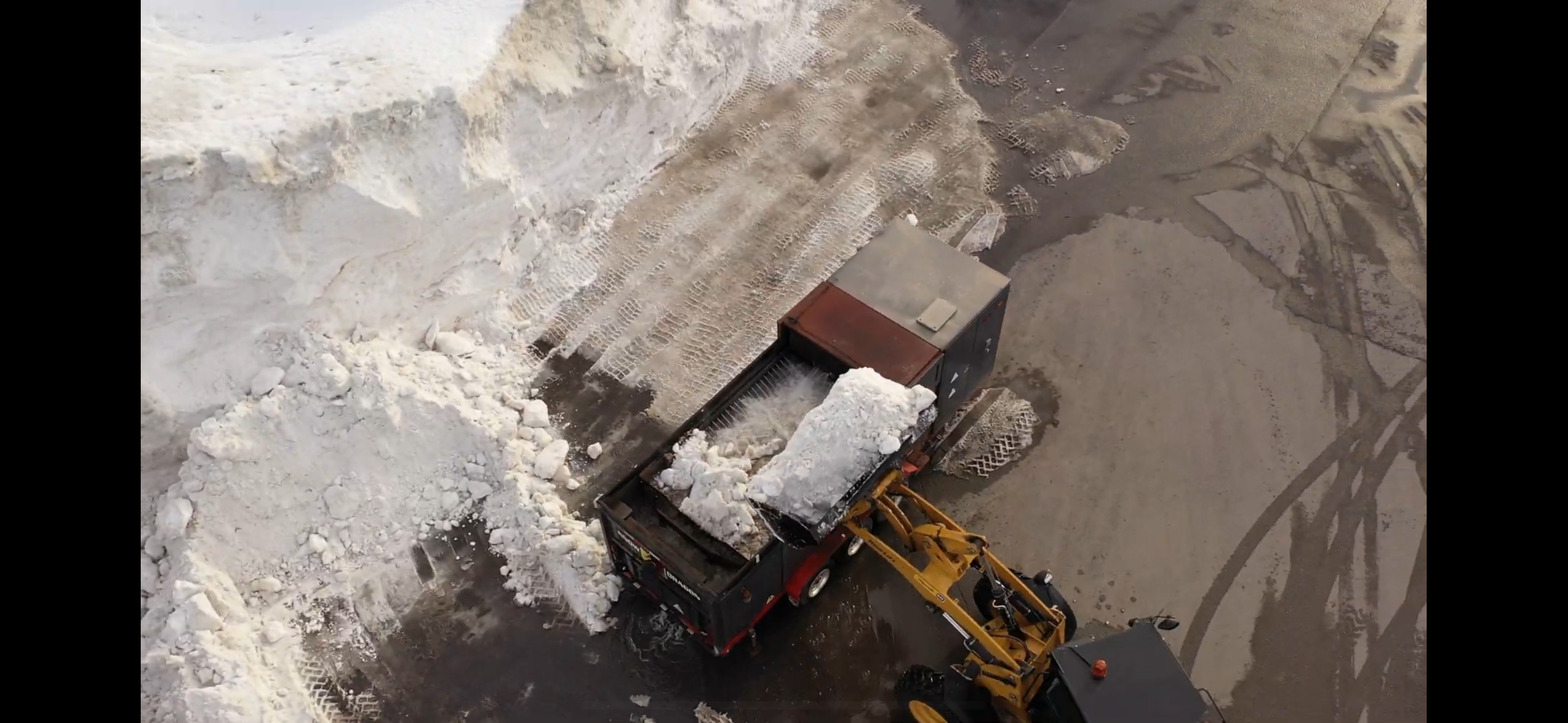 Loader dumping snow